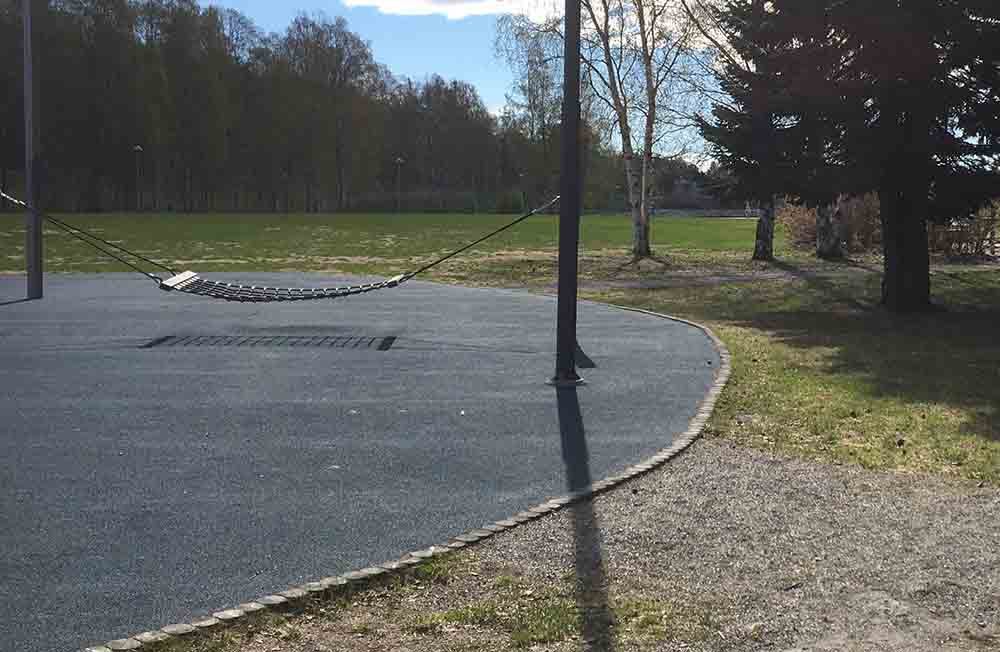 Hängmatta mellan två stolpar i metall. Underlaget är mjukgjort och har en blå färg.