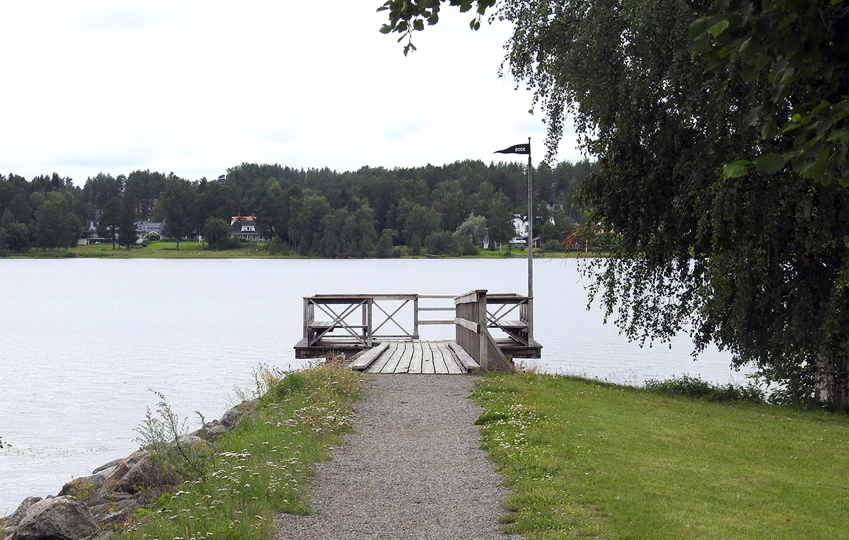 Brygga som går ut i älven vid Residensparken. Längst ut står en bänk.