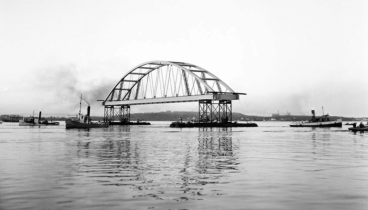 Bågspannen till Bergnäsbron transporteras på älven.